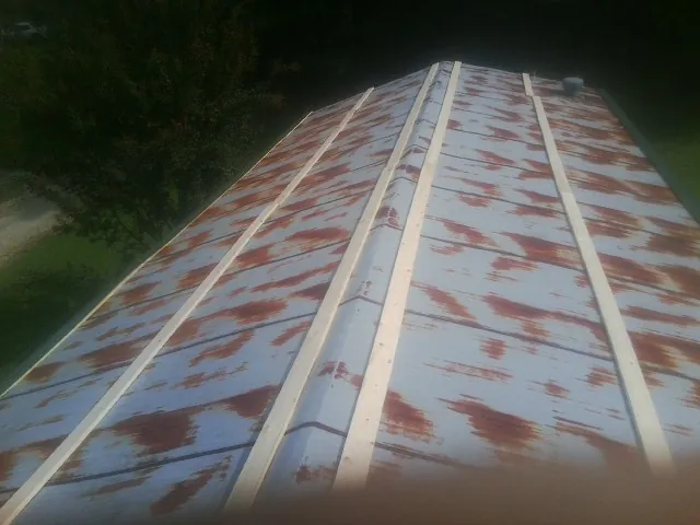 Rusted metal roof panels with new wood purlins before replacement — Storm Damage Roof Repair in Sturgis by Roofing Brothers